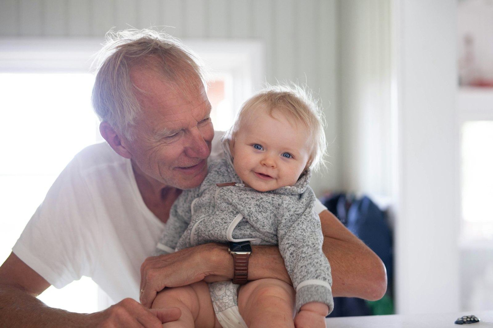 A grandfather holding a smiling baby