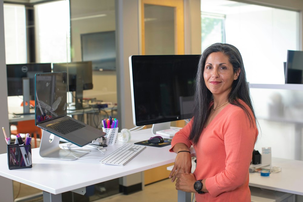 A woman standing at a desk in a bright office